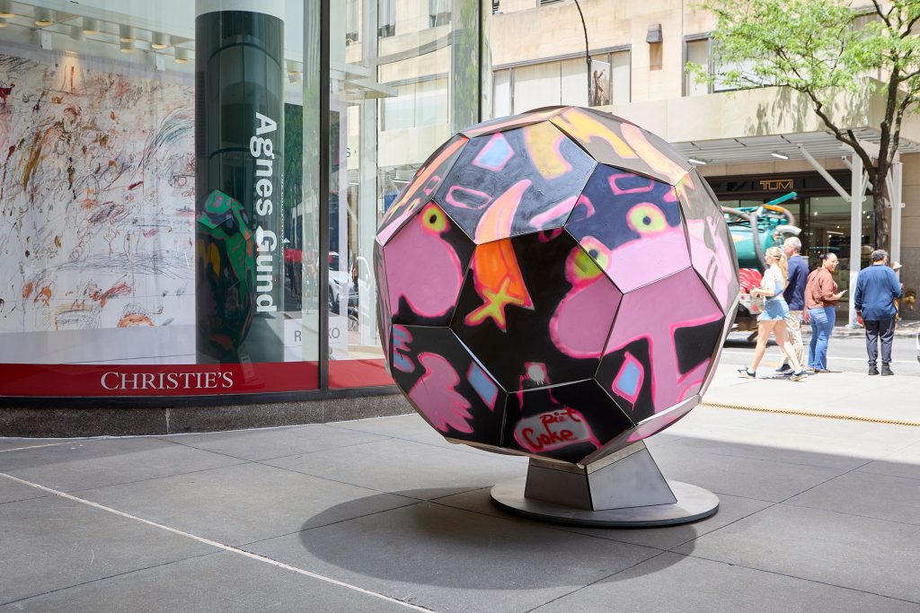 Large soccer ball sculpture in front of Christie's covered with painted images of the Pink Panther